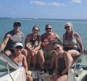 A cheerful group of friends enjoys a day on the water, capturing memories aboard their boat. Perfect for celebrating special moments with loved ones.
