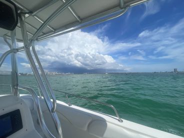 A scenic view from the deck of a boat, showcasing the vibrant waters and distant skyline, perfect for capturing the essence of a day on the water.