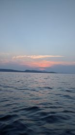 A serene sunset over the coastline, reflecting beautifully on the water — a perfect moment for relaxation and appreciation of nature's beauty.