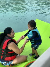 A joyful moment between a mother and her child as they enjoy water activities together, showcasing family fun and bonding in a beautiful aquatic setting.