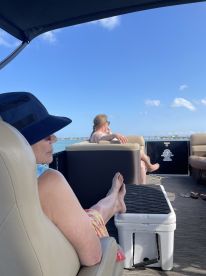 Two friends relax on a boat under the sunny sky, enjoying a leisurely day on the water — perfect for unwinding and socializing.
