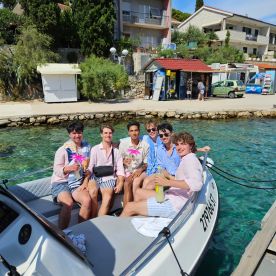 A lively group of friends enjoys refreshing cocktails aboard a boat, perfect for summer celebrations and fun outings on the water.