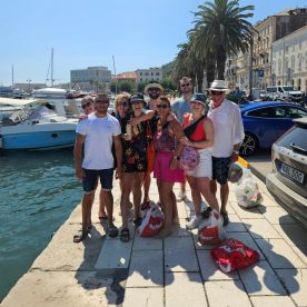 A cheerful group of friends poses together at the dock, enjoying a sunny day by the water — perfect for memorable boating adventures and celebrations.