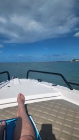 A relaxing moment on the bow of a boat, showcasing a serene ocean view under a beautiful sky — perfect for unwinding on a sunny day.