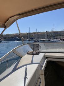 A view from the helm of a boat, showcasing the interior space and the scenic harbor in the background, perfect for enjoying a day on the water.