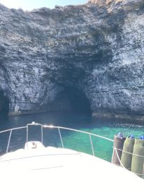 A stunning view from the bow of a boat approaching a natural cave, showcasing the crystal-clear waters and rocky cliffs — perfect for exploring coastal wonders.