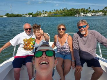 A joyful group of friends enjoys a sunny day on the water, capturing memories aboard their boat — perfect for fun outings and celebrations.