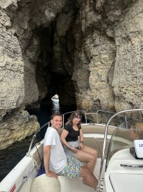 A couple enjoys a scenic boat ride through a stunning cave, showcasing the beauty of nature and adventure on the water.