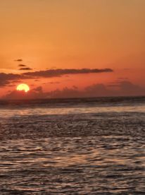 A beautiful sunset over the ocean, creating a serene and picturesque scene.