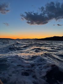 A stunning sunset over the water, capturing the tranquil beauty of the coastline — perfect for evening boat trips and scenic views.