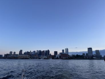 A stunning view of the city skyline at sunset from the water, showcasing the vibrant urban landscape and tranquil waters — perfect for evening boat tours.