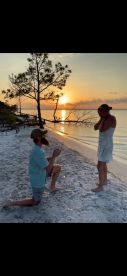 A romantic sunset proposal on the beach captures a couple's special moment, perfect for unforgettable celebrations and engagements.
