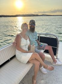 A couple enjoys drinks while seated on a boat at sunset, creating a perfect romantic atmosphere for memorable moments on the water.