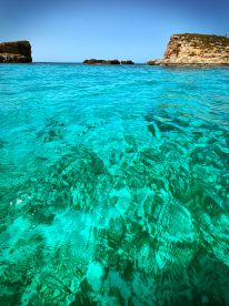 A stunning view of crystal-clear turquoise waters and rocky coastlines, perfect for showcasing the beauty of a tropical destination.