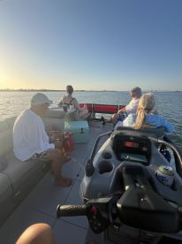 A group of friends enjoys a relaxing day on the water, soaking in the sunset while aboard a pontoon boat — perfect for unwinding and creating lasting memories.