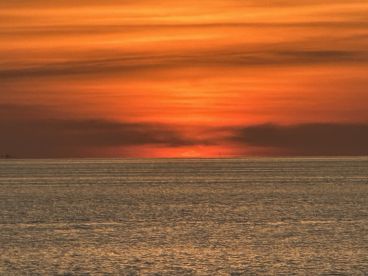 A stunning sunset over the ocean, creating a picturesque backdrop for any boating adventure. The tranquil waters reflect the vibrant colors of the sky, perfect for evening cruises.