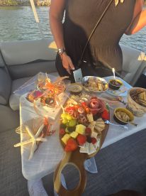 A beautifully arranged charcuterie board featuring an assortment of fruits, cheeses, and snacks, perfect for enjoying on a boat. Ideal for sunset cruises or gatherings with friends.