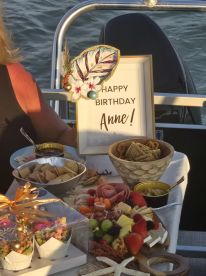 A beautifully arranged birthday spread featuring a variety of snacks and treats, perfect for celebrating special occasions on the water.