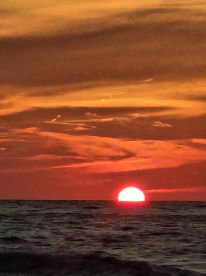 A stunning sunset over the ocean, creating a picturesque backdrop for evening boat cruises and tranquil moments on the water.