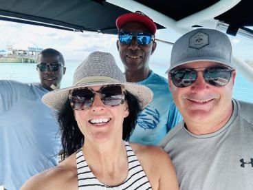 A cheerful group of friends poses for a selfie on a boat, capturing the joy of their aquatic adventure together.
