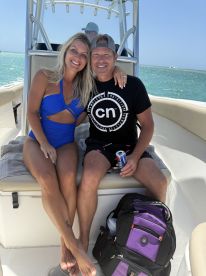 A happy couple enjoys a sunny day on a boat, capturing a moment of relaxation and celebration on the water.