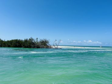 A picturesque view of a secluded island surrounded by turquoise waters, perfect for exploring and relaxing in nature.