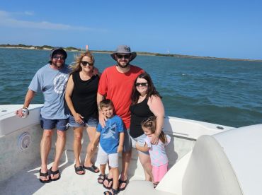 A cheerful family poses together on a boat, enjoying a sunny day on the water — perfect for creating lasting memories during their boating adventures.