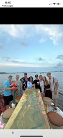 A joyful group of family and friends gathers on a boat, celebrating together with stunning waterfront views — perfect for memorable gatherings and special occasions.