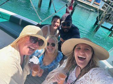 A joyful group of friends enjoys cocktails on a boat, capturing the essence of fun and celebration on the water.