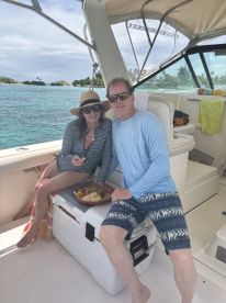 A couple enjoys a delicious spread of snacks on a boat, showcasing the perfect amenities for a relaxing day on the water.