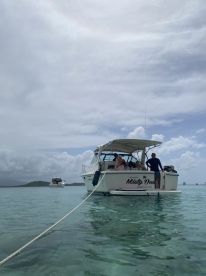 A group enjoys a day on the water aboard the 'Misty Day,' anchored in clear turquoise waters, perfect for relaxation and fun activities.