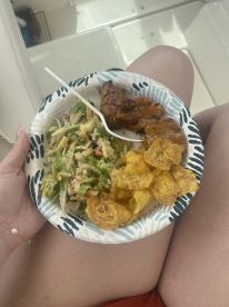 A delicious plate of food featuring chicken, salad, and plantain chips enjoyed on board — perfect for a day out on the water.