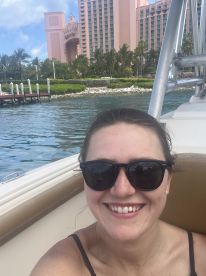 A joyful selfie taken on a boat with a stunning resort backdrop, capturing the essence of a fun day on the water.