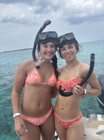 Two friends excitedly pose for a photo before snorkeling in crystal-clear waters, capturing the essence of adventure and fun on their aquatic journey.