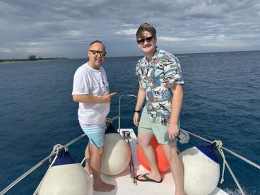 Two friends enjoy a sunny day on the boat, showcasing the fun and camaraderie of a perfect ocean adventure.