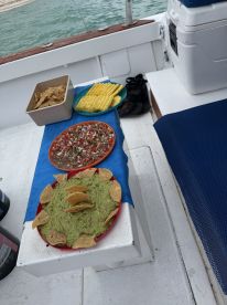 A delicious spread of guacamole, salsa, and snacks laid out on a boat, perfect for enjoying while cruising the waters.