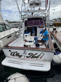 A view of the interior of the 'Why Nat' fishing boat, showcasing seating and helm areas, perfect for fishing adventures and day trips on the water.