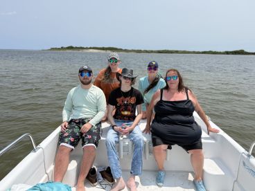 A cheerful group of friends enjoys a day on the water, showcasing the fun and camaraderie of a boat trip.