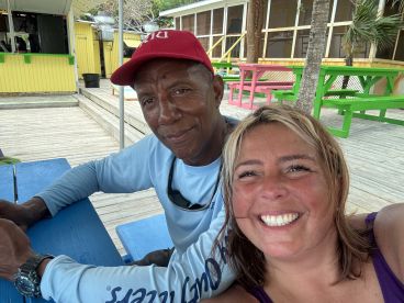 A joyful selfie captures two friends enjoying their time together at a vibrant outdoor setting, perfect for creating lasting memories during their boating adventure.