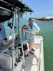 A group of friends celebrates a successful fishing trip aboard a boat, showcasing their catch in the beautiful waters. Perfect for fishing enthusiasts and adventure seekers.