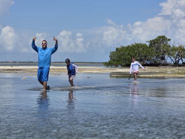 A fun-filled moment with a group enjoying shallow waters, showcasing playful interactions and a vibrant beach atmosphere.