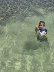 A joyful child plays in the clear waters, showcasing a fun day of swimming and exploration — perfect for family adventures in nature.