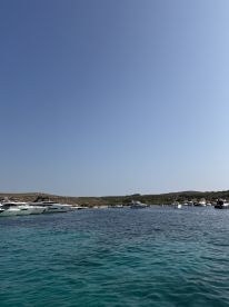 A picturesque view of a harbor filled with various boats, showcasing the serene turquoise waters and the surrounding landscape — perfect for boating enthusiasts and travelers seeking scenic destinations.
