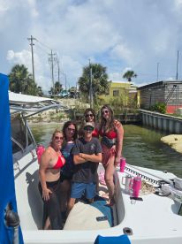 A lively group of friends poses on a boat, enjoying a sunny day on the water — perfect for summer parties and fun outings.
