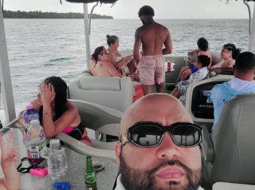 A lively group enjoys a fun day on the water aboard a boat, complete with drinks and camaraderie — perfect for a memorable outing with friends.