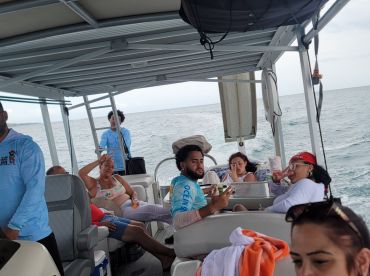 A lively group enjoys their time aboard a boat, engaging in conversation and relaxation on the water — perfect for a fun day out with friends.