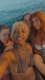 A joyful group of friends poses for a selfie on a boat, capturing the essence of fun and camaraderie on the water.