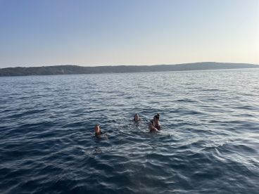 A group of friends enjoys a refreshing swim in the ocean, capturing the essence of summer fun and adventure on the water.