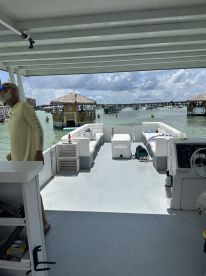 The interior of a pontoon boat showcases comfortable seating and a helm, perfect for relaxing while cruising through scenic waters.