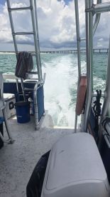 Interior view of a boat's helm area, showcasing seating and equipment as it speeds through the water, perfect for a day of adventure on the waves.